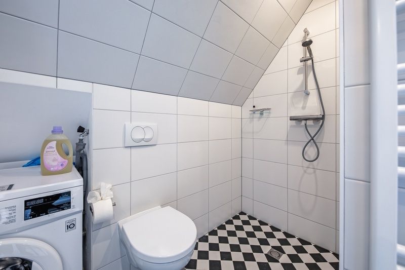 Bathroom with washing machine in Hotel Loodsmans Welvaren - Apartment, Den Hoorn, Texel.