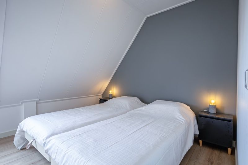 Bedroom with two beds in Hotel Loodsmans Welvaren - Apartment, Den Hoorn, Texel.