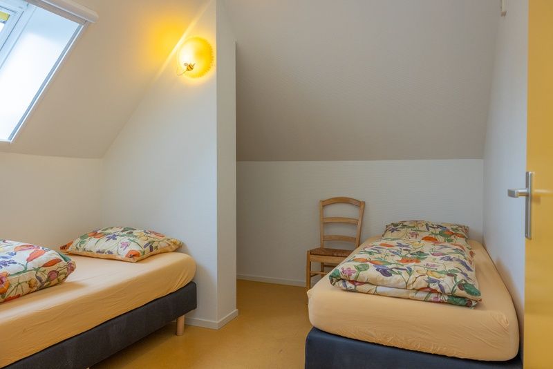 Gemuetliches Schlafzimmer im Apartment Geel, Den Hoorn, Texel mit zwei Betten und natuerlichem Licht fuer einen entspannten Aufenthalt auf den Watteninseln.