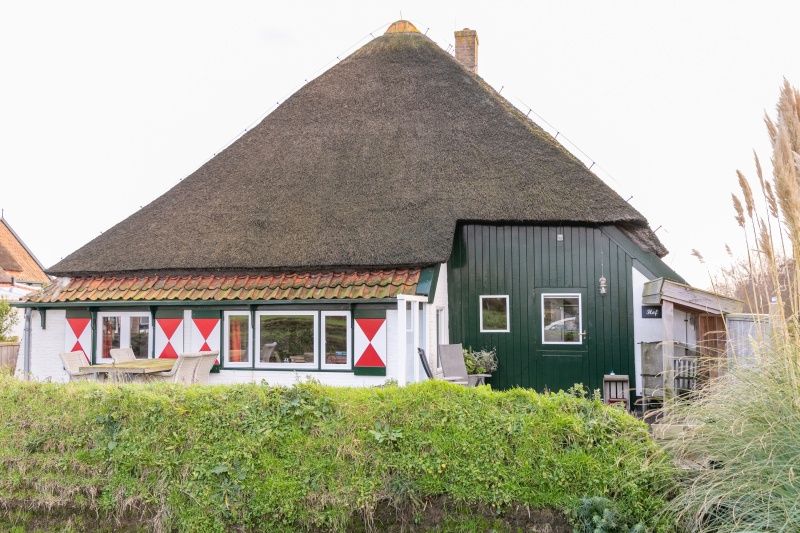 Exterior of Apartment Hof, Den Hoorn, Texel, vacation home with thatched roof and terrace.