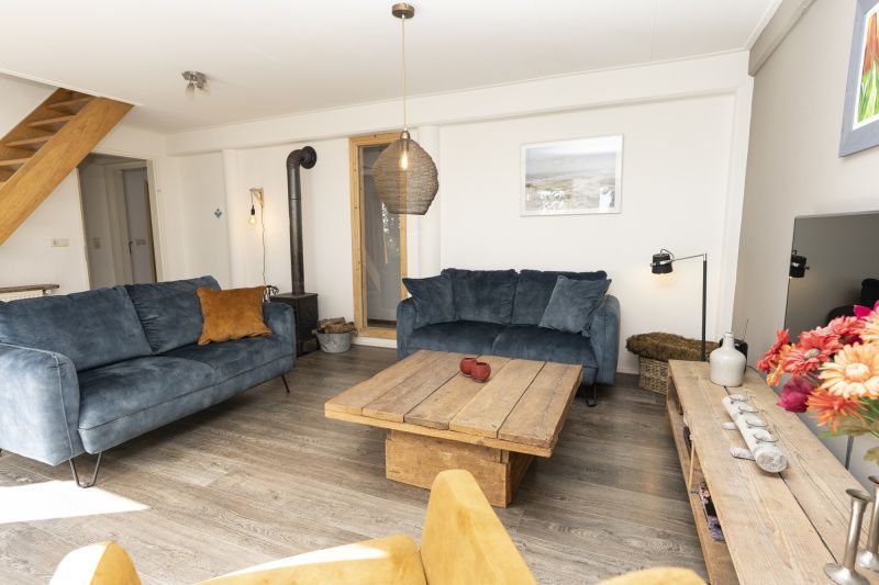 Gemuetliche Einrichtung des Ferienhauses Sil, Den Hoorn, Texel mit Holzofen und Holzmoebeln.