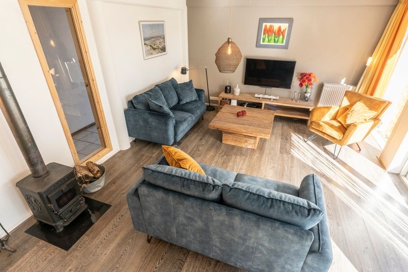 Uebersicht des Wohnzimmers im Ferienhaus Sil, Den Hoorn, Texel mit Sitzecke und Holzboden.