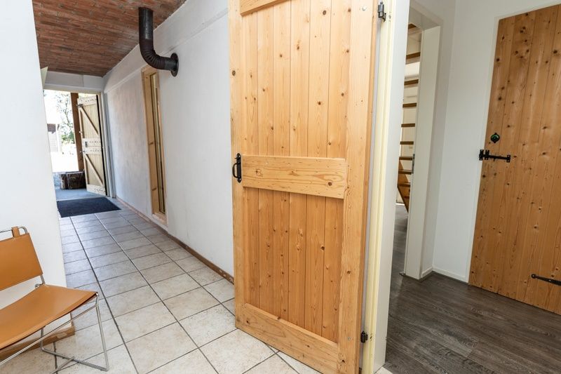 Eingang zum Ferienhaus Sil, Den Hoorn, Texel mit Holztueren und Fliesenboden.