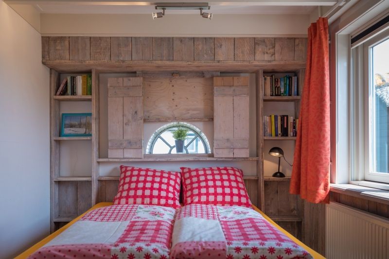 Sfeervolle slaapkamer in Appartement Heem, Den Hoorn, Texel, met gezellige bedden en een raam met uitzicht op de omgeving.