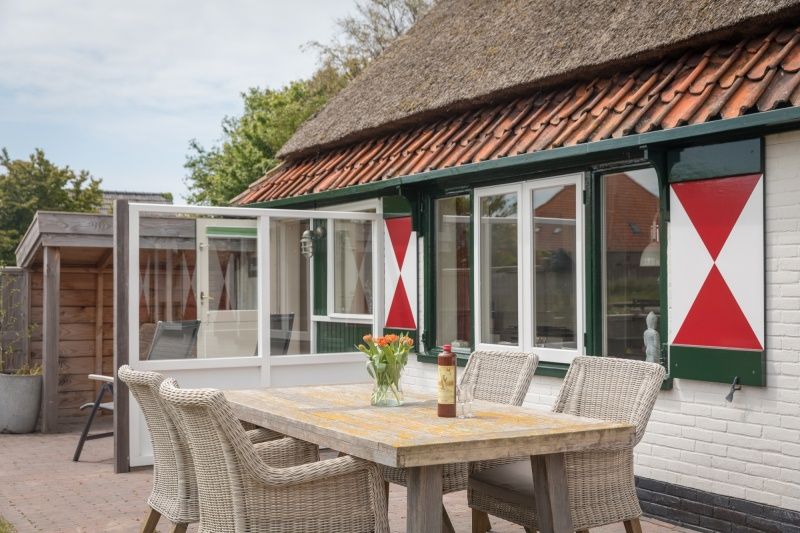 Gezellig terras van Appartement Heem, Den Hoorn, Texel, perfect voor buiten dineren en genieten van de Texelse natuur.
