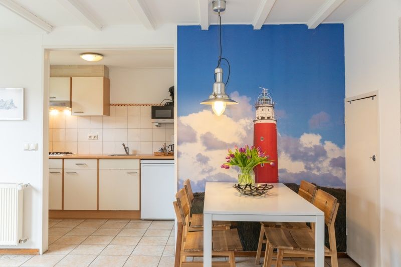 Essbereich in Konijnenhol Den Hoorn mit Texel-Leuchtturmwand und moderner Kueche.