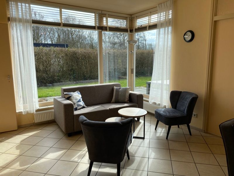 Bright sitting area in Garden Wall vacation home, Oosterend Texel with garden view.