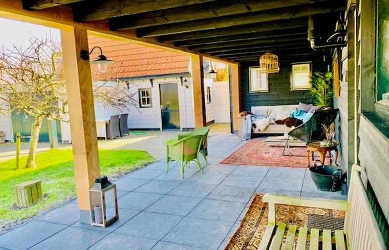 Cozy veranda at Holiday home in Oosterend, Texel, with comfortable seating and views of the garden.