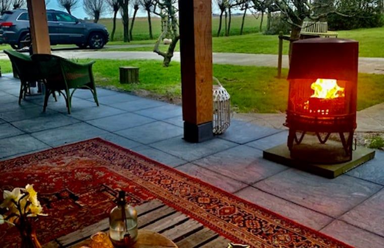 Cozy terrace with fireplace at Holiday home in Oosterend, Texel, ideal for evenings in nature.