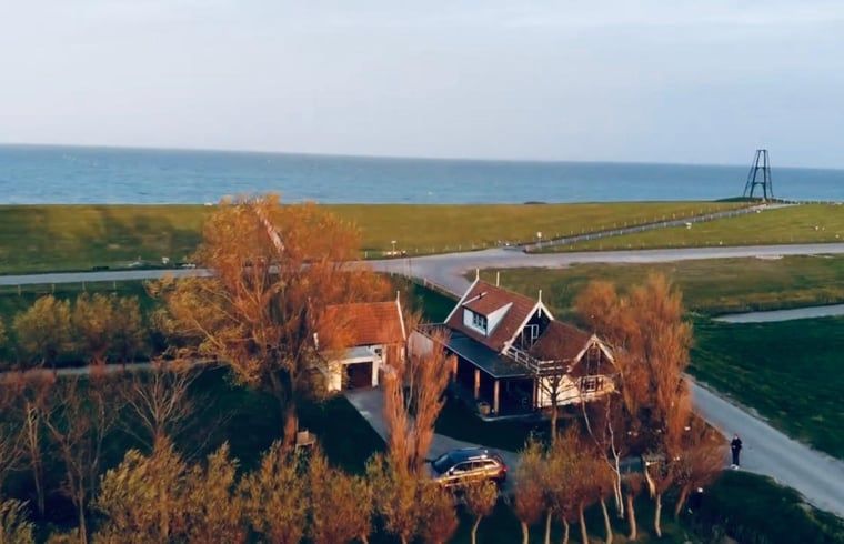 Aerial view of Holiday home in Oosterend, Texel, overlooking the sea and green fields.
