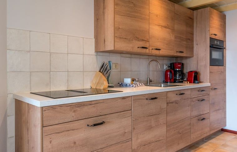 Moderne Kueche im Ferienhaus in Oosterend, Texel, Ferienhaus mit Holzschraenken auf den Watteninseln.