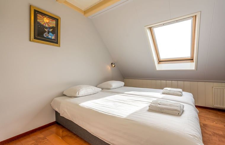 Schlafzimmer im Ferienhaus in Oosterend, Texel, Ferienhaus mit Doppelbett und Dachfenster auf den Watteninseln.