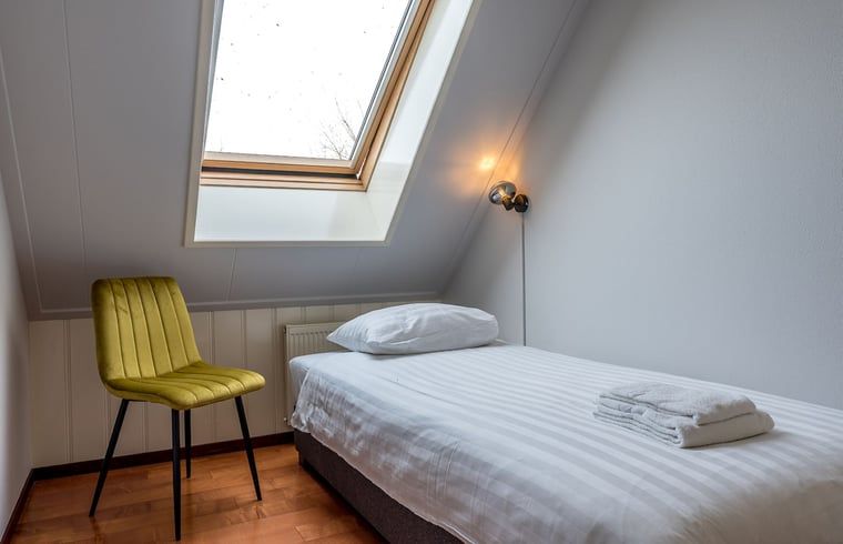 Helles Schlafzimmer im Ferienhaus in Oosterend, Texel, Ferienhaus mit Einzelbett und Dachfenster auf den Watteninseln.