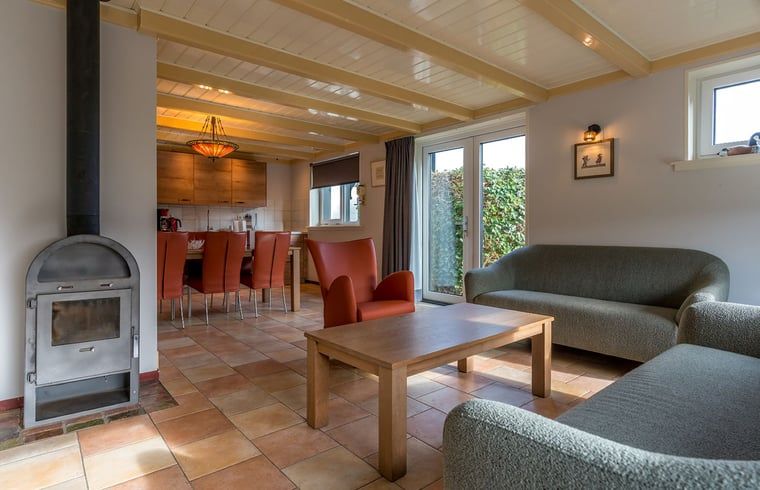 Open living space in Holiday home in Oosterend, Texel, with wood stove and dining area.
