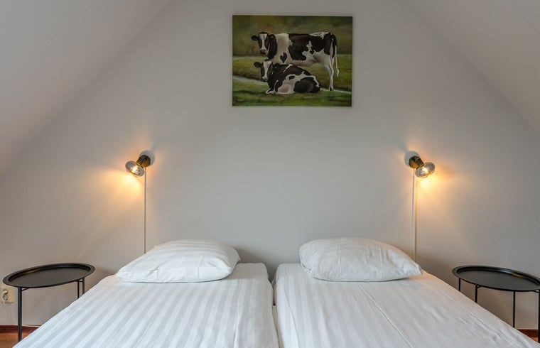 Second bedroom in Holiday home in Oosterend, Texel, with paintings of cows.