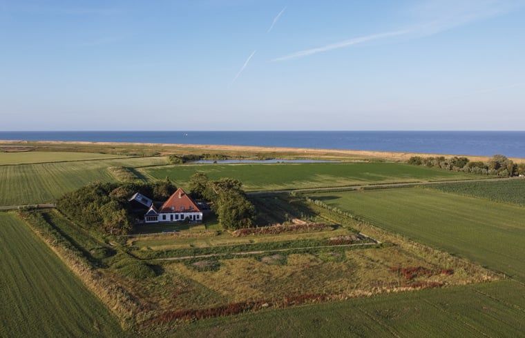 Aerial view of Holiday home in Oosterend, Texel. Beautiful view of sea and nature around the vacation home.