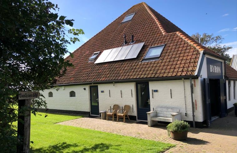 Front of Holiday home in Oosterend, Texel with sitting area. Charming vacation home on the Wadden Islands.