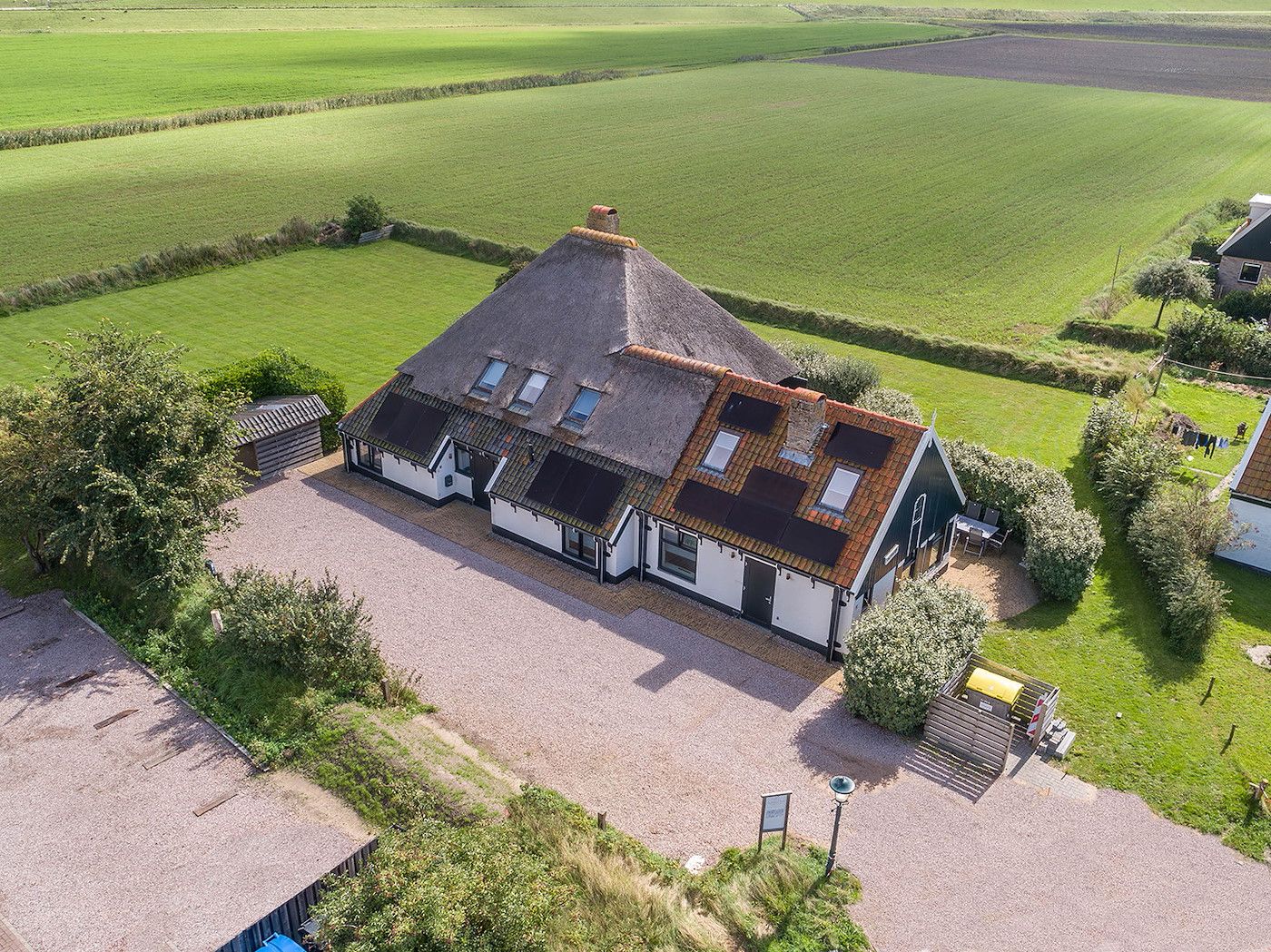 Aerial view of Zilverling vacation home in Oosterend, Texel, surrounded by green fields.