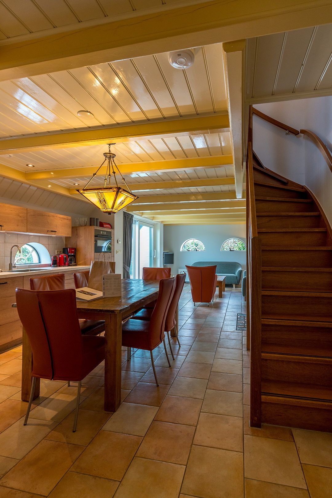 Spacious dining room with wooden stairs in Zilverling vacation home in Oosterend, Texel.