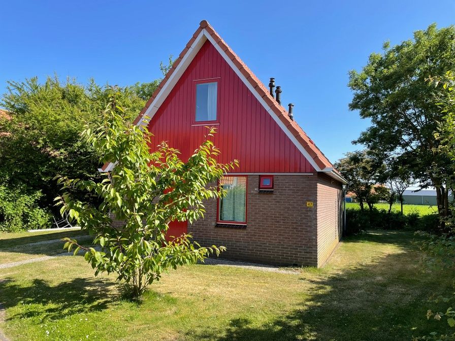 Type II - nr. 47 Koolmees, vakantiehuis in Oosterend, Texel, met charmante rode gevel en groene tuin.