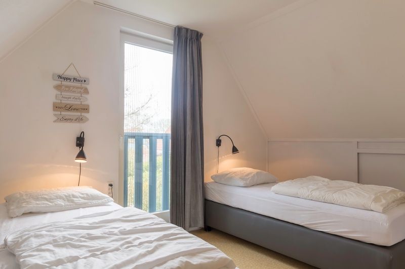 Second bedroom in Type I - No. 55 Marel, Oosterend Texel, with cozy furnishings and lots of natural light, ideal for a relaxing stay on the Wadden Islands.