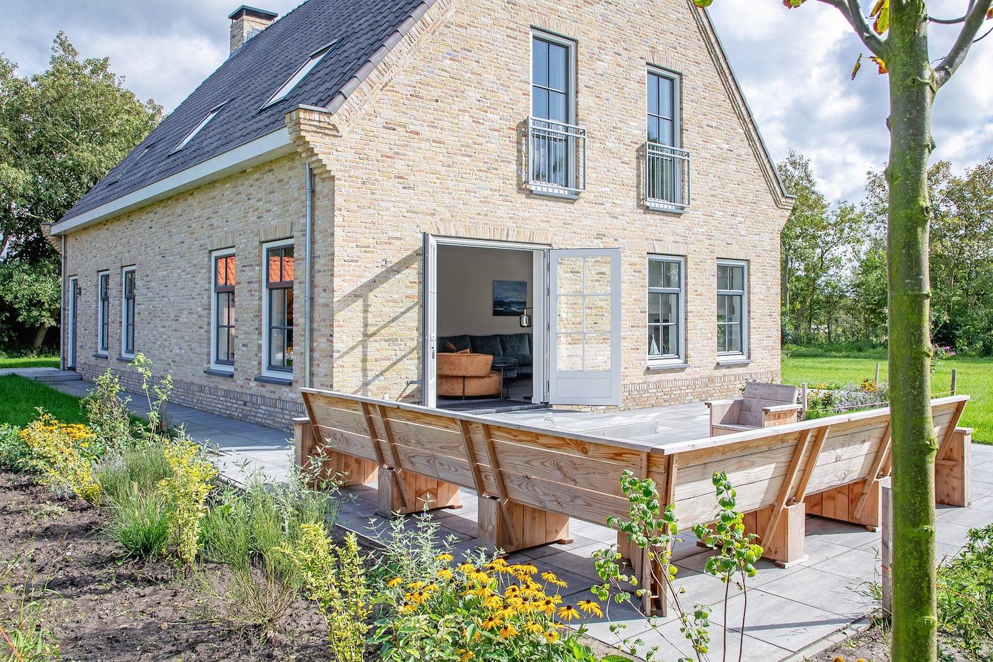 Zijaanzicht van 46 - Nieuw Zeeland vakantiehuis in Oosterend, Texel met bloeiende tuin.
