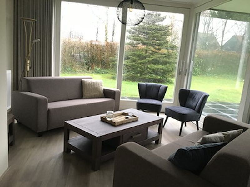 Cozy living room in vacation home Vuurtoren, Oosterend, Texel overlooking the garden.