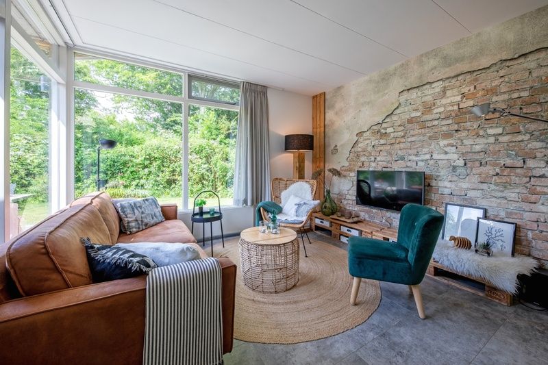 Cozy living room in Bungalowpark De Toes - Zeewier, Oosterend, Texel, with comfortable seating area and views of nature.