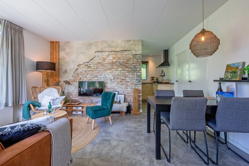 Stylish dining area and open kitchen in vacation home Bungalowpark De Toes - Zeewier, Oosterend, Texel, ideal for family dinners.