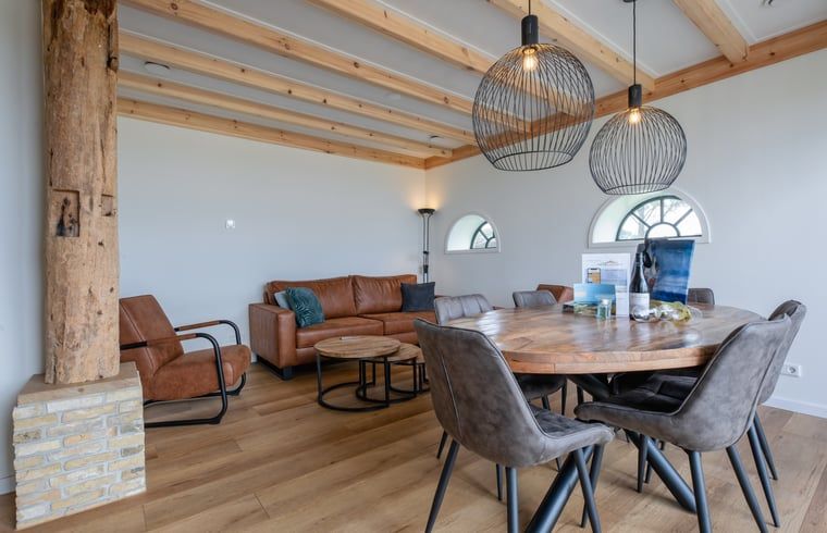 Gemuetliches Wohnzimmer im Cottage in Oudeschild, Texel, mit Holzbalken und komfortablen Moebeln.