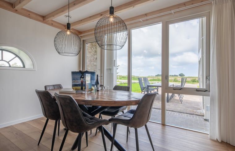 Esszimmer im Ferienhaus in Oudeschild, Texel, mit Blick auf die Natur und moderner Einrichtung.