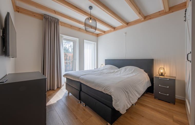Schlafzimmer in Haus in Oudeschild, Ferienhaus Texel, mit bequemem Doppelbett und natuerlichem Licht.
