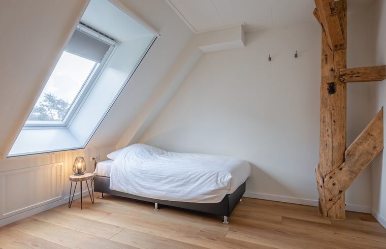 Gemuetliches Schlafzimmer in Haus in Oudeschild, Ferienhaus Texel, mit Holzdetails und Dachfenster.