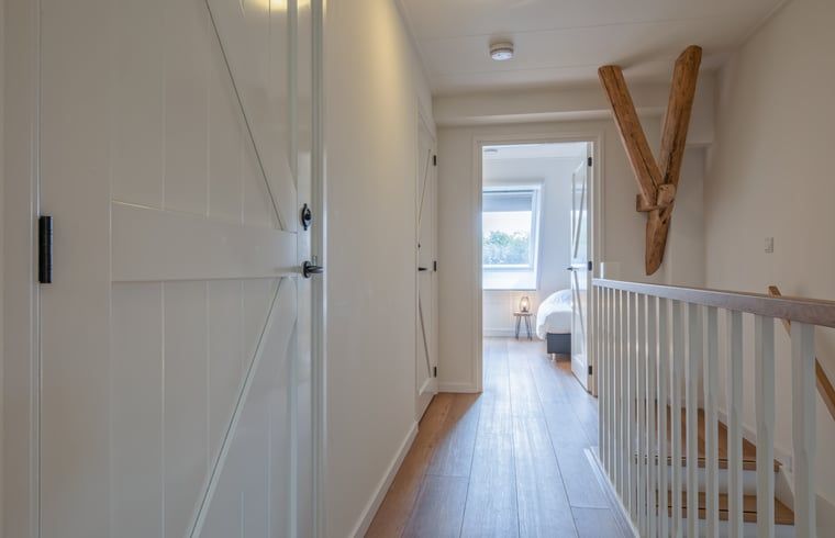 Heller Flur im Ferienhaus in Oudeschild, Texel, mit Zugang zu den Schlafzimmern und dem Badezimmer.