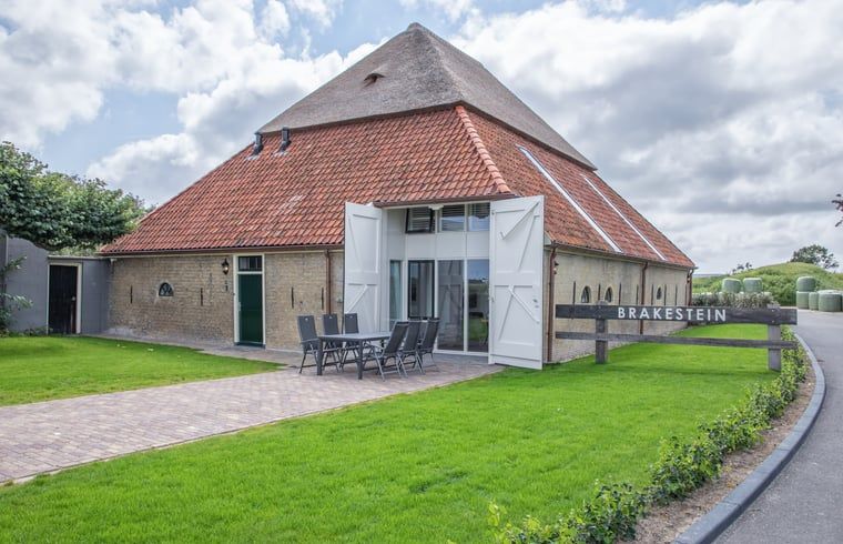 Cottage in Oudeschild, Texel, mit einladender Terrasse und gruener Umgebung.