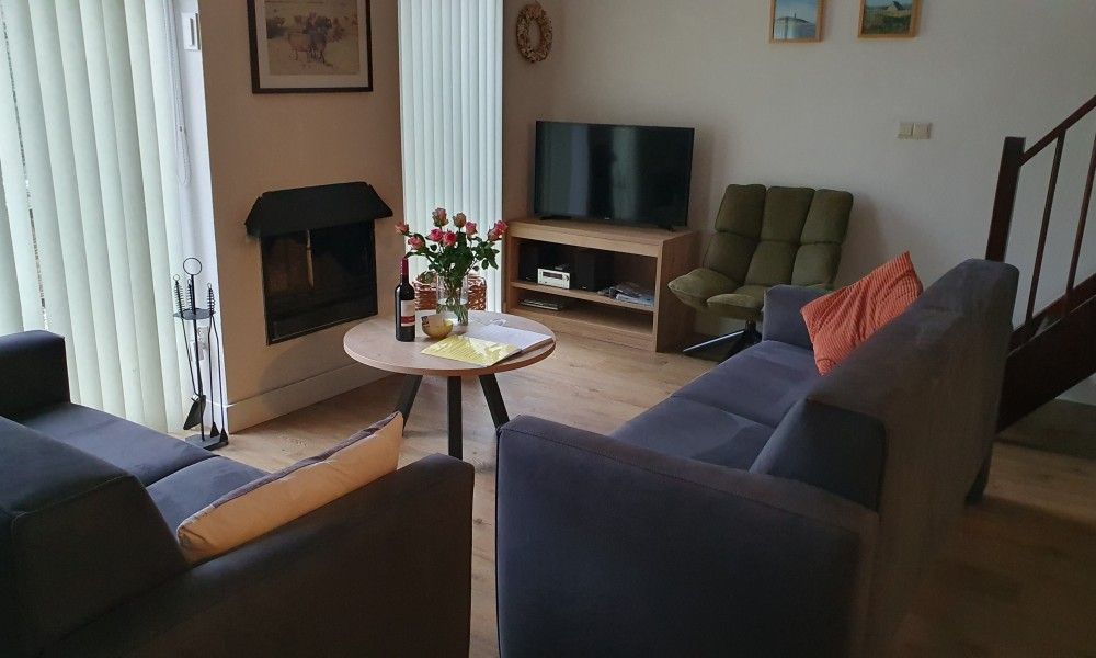 Cozy living room with fireplace in Alkema bungalow rental Gortersmient, Texel Wadden Islands.
