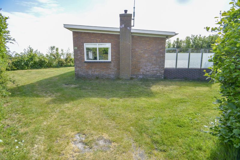 Vooraanzicht van Slufterbungalows 362 in Bungalowpark Slufteroord, Texel met ruime grasvelden.