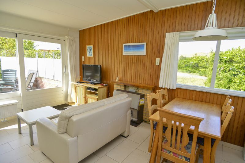 Gezellige woonkamer van Slufterbungalows 362 in Bungalowpark Slufteroord, Texel met houten interieur.