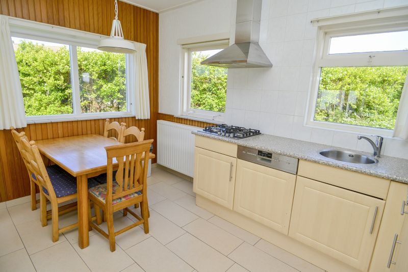Eethoek en keuken van Slufterbungalows 362 in Bungalowpark Slufteroord, Texel met uitzicht op tuin.