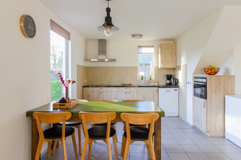 Dining area in De Triaan vacation homes, Zuid-Eierland, Texel, with spacious table and lots of natural light.