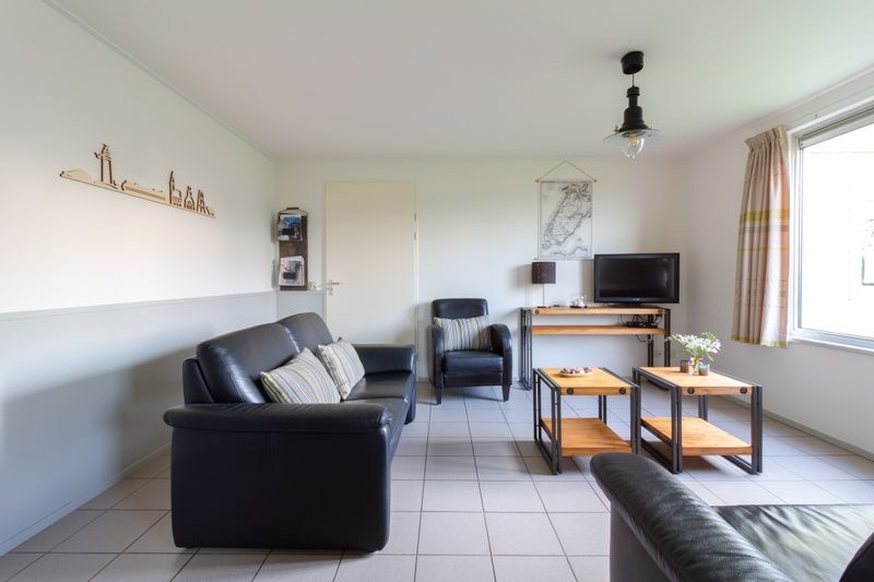 Cozy living room in De Triaan vacation homes, Zuid-Eierland, Texel, with comfortable seating.