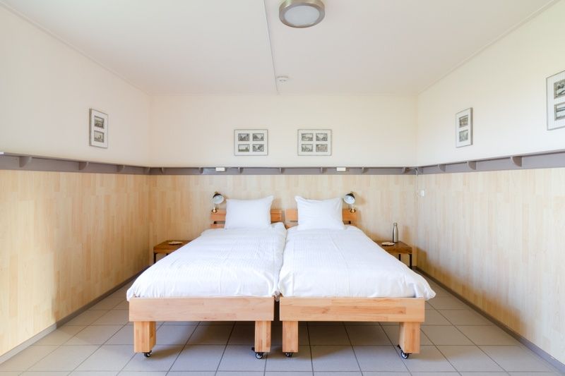 Spacious bedroom in De Triaan vacation homes, Zuid-Eierland, Texel, with two single beds and bright decor.