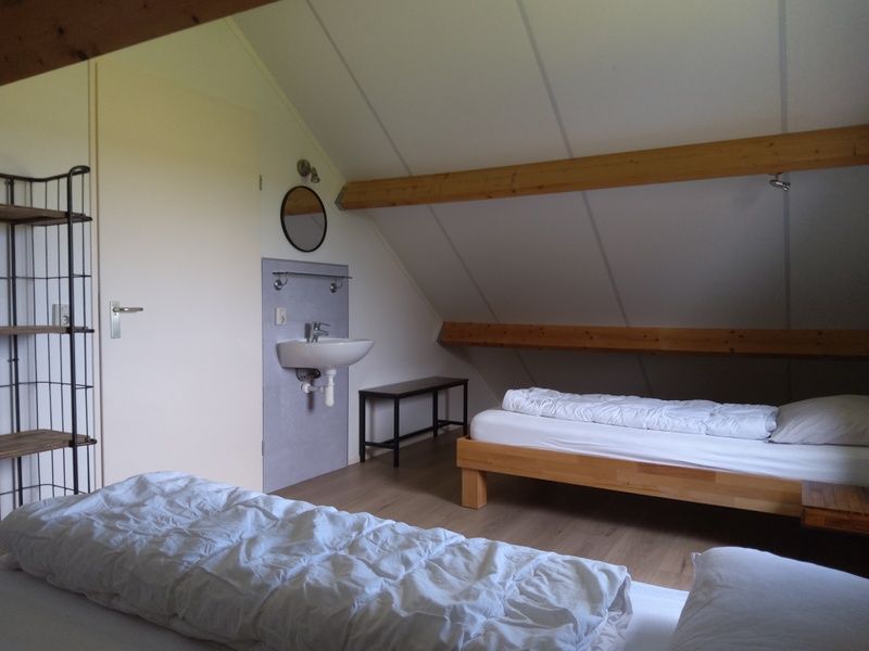 Attic space in De Triaan vacation homes, Zuid-Eierland, Texel, with beds and sink for extra comfort.