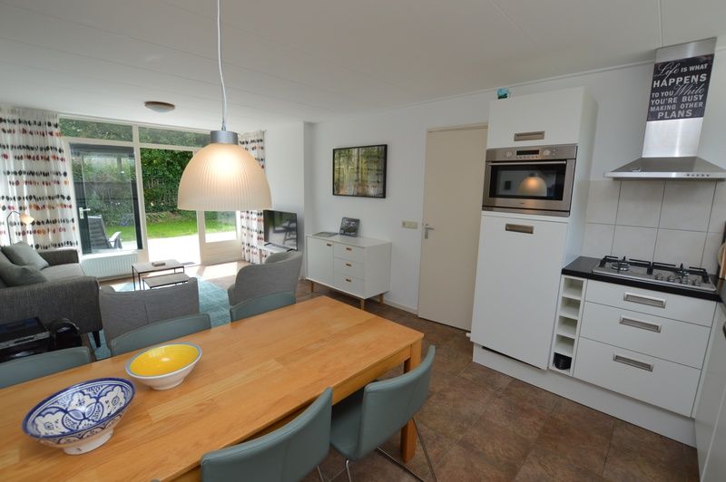 Offene Kueche und Wohnzimmer im Ferienhaus de Parel 182, Texel mit modernen Geraeten.