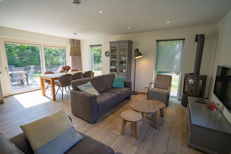 Heller Wohnbereich im Ferienhaus de Parel 150, De Dennen, Texel mit Blick auf den Garten.