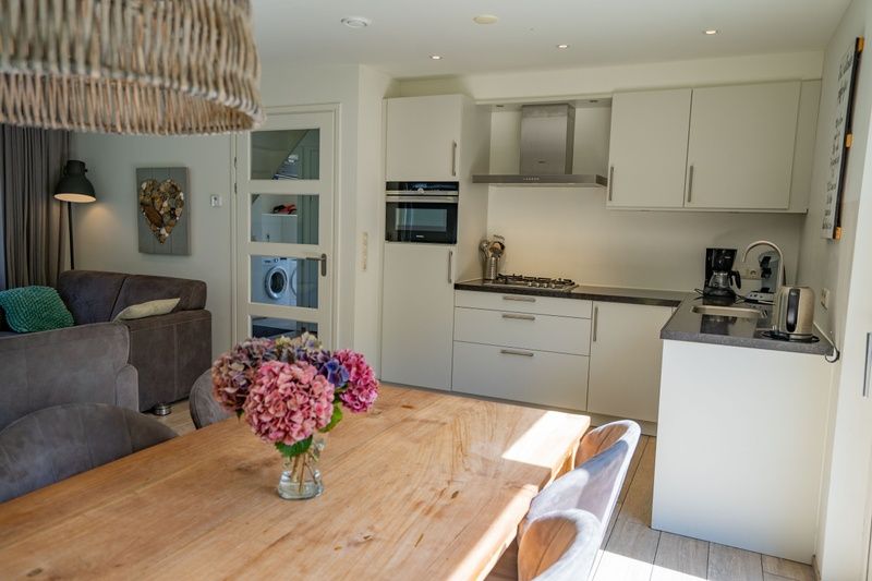 Moderne Kueche im Ferienhaus de Parel 150, De Dennen, Texel mit Essecke.