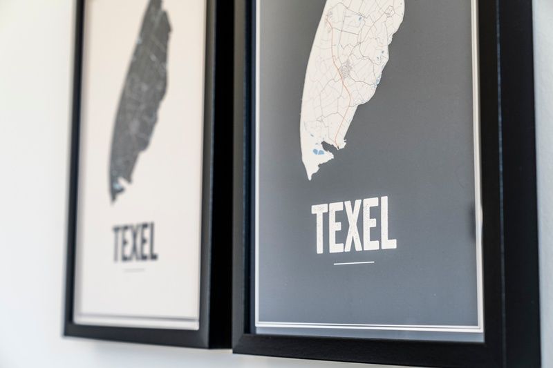 Wall decoration in Holiday Home 2 on Texel with maps of the island.