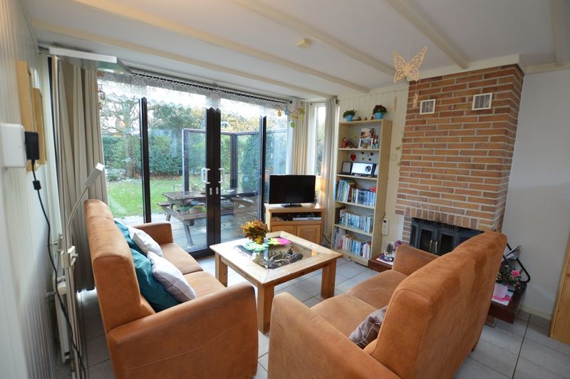 Gezellige woonkamer in Vakantiehuis de Parel 212, De Dennen, Texel met uitzicht op groene omgeving.