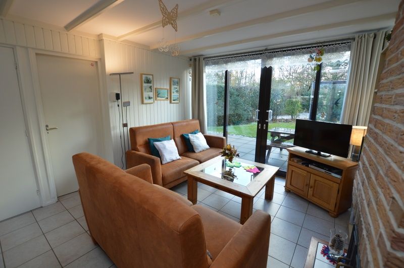 Comfortabele zithoek in Vakantiehuis de Parel 212, De Dennen, Texel met toegang tot de tuin.