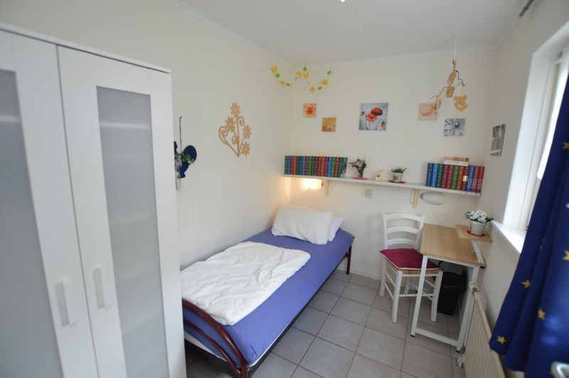 Slaapkamer met eenpersoonsbed in Vakantiehuis de Parel 212, De Dennen, Texel.